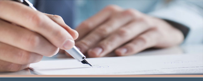 Mit einem Füller unterschreibt eine Hand ein Dokument